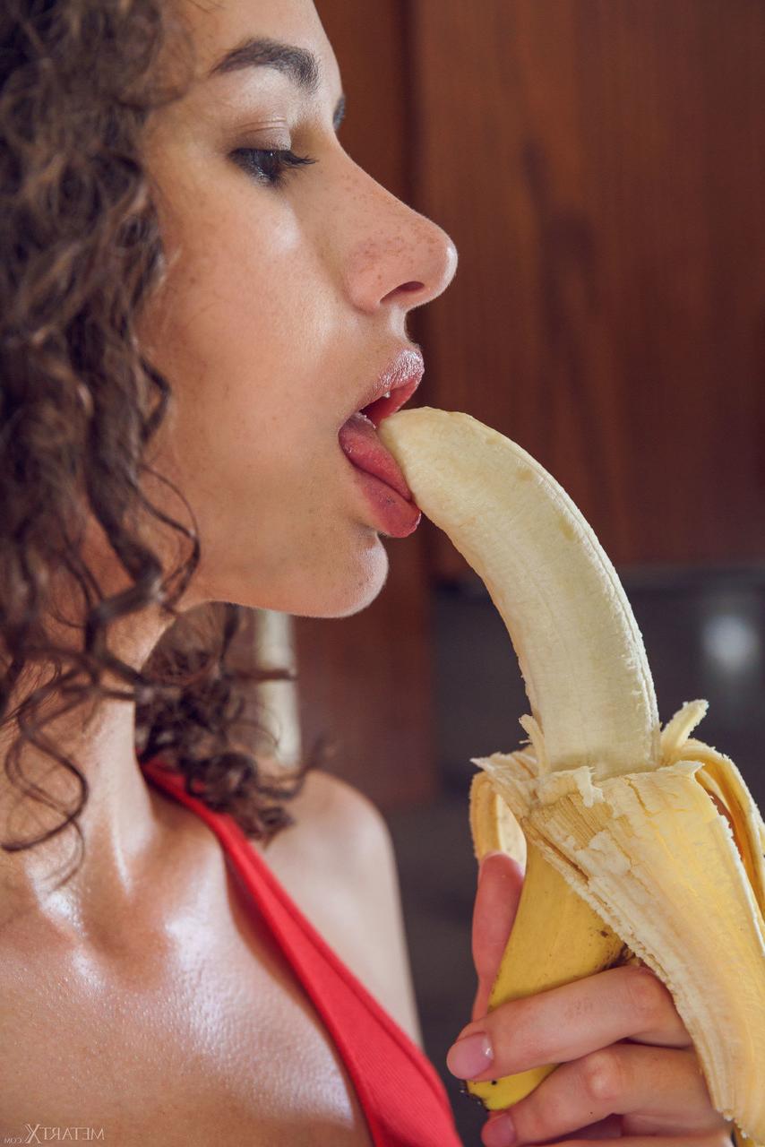 20P Brunette teen Cristin fondles her juggs and stirps while sucking on a banana