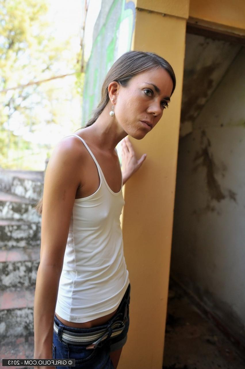 12P Une fille maigre enlève son short en jean pour poser nue devant des graffitis
