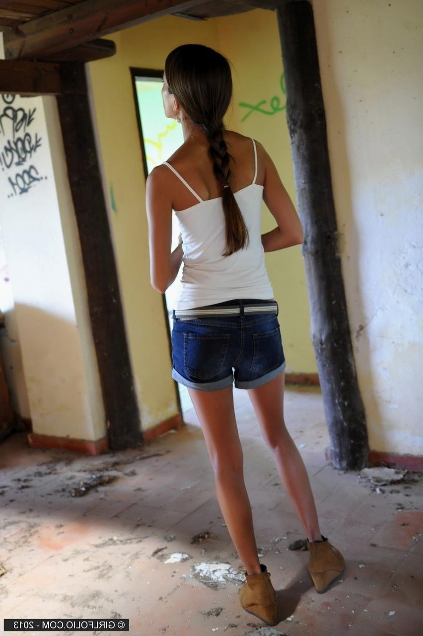 12P Une fille maigre enlève son short en jean pour poser nue devant des graffitis