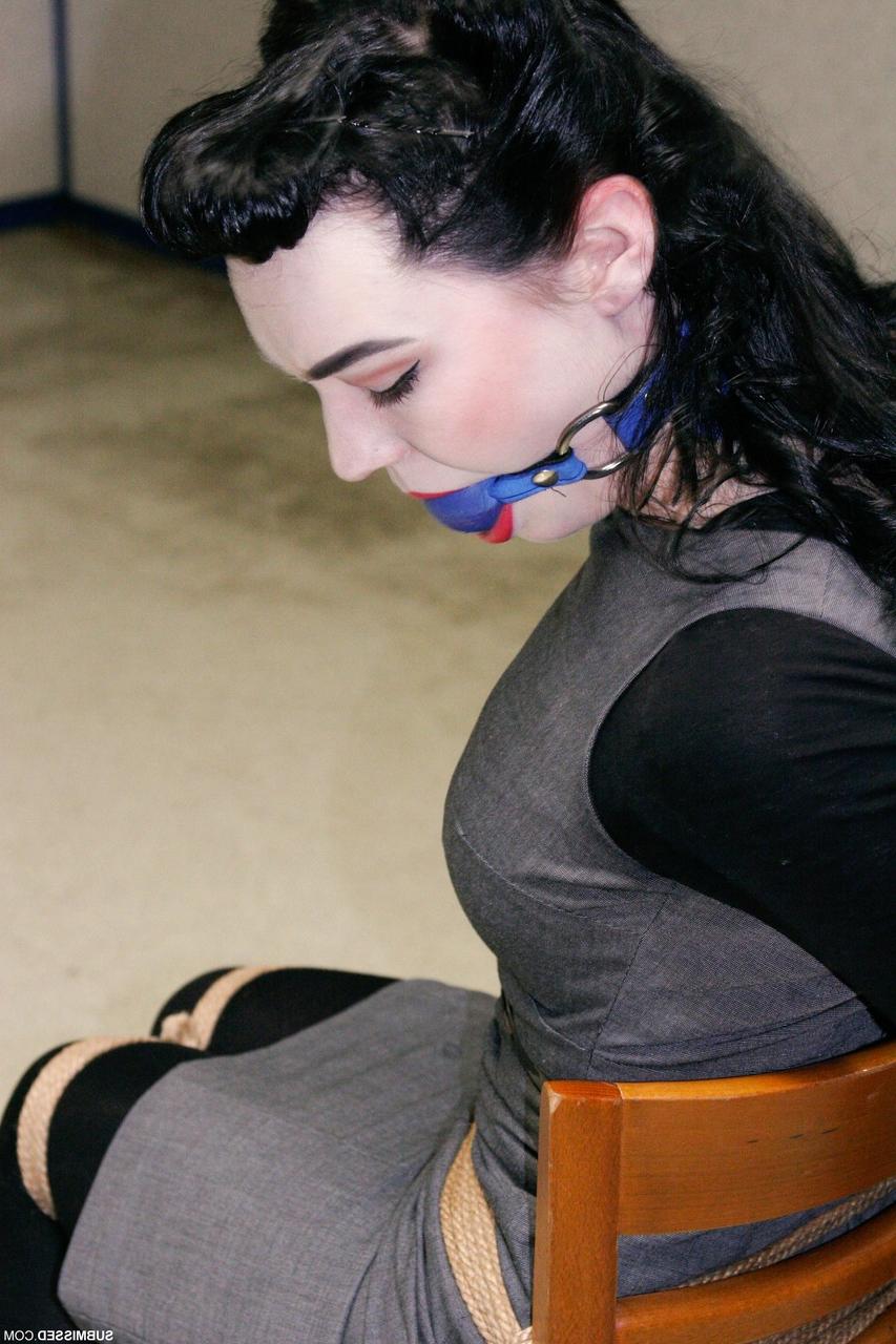 20P Fully clothed gagged babe Lilly struggles to be free of her rope bondage