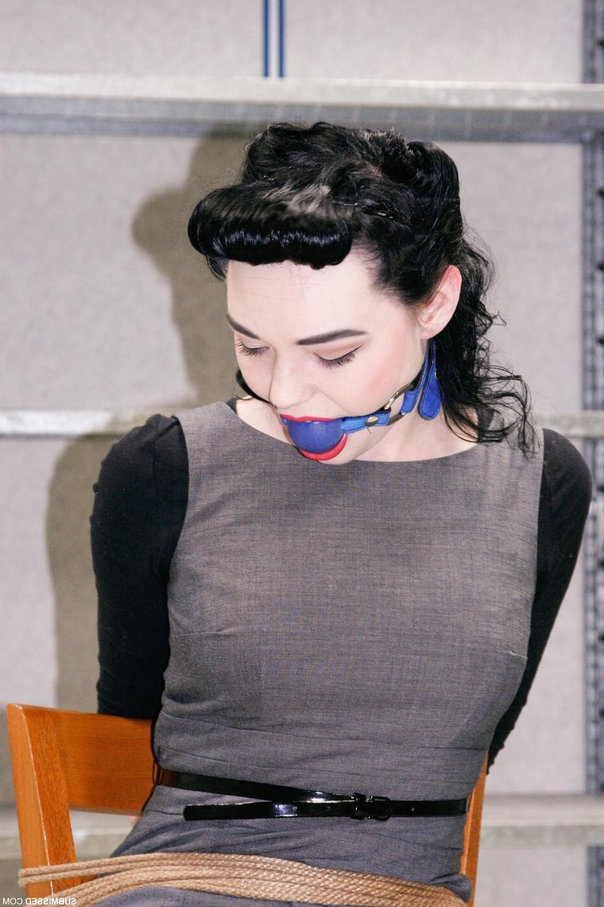 20P Fully clothed gagged babe Lilly struggles to be free of her rope bondage