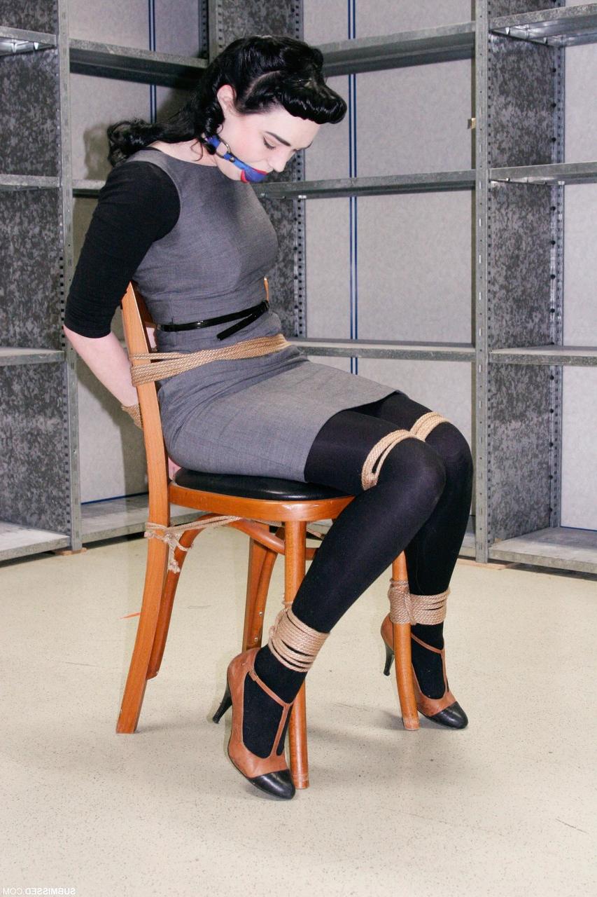20P Fully clothed gagged babe Lilly struggles to be free of her rope bondage