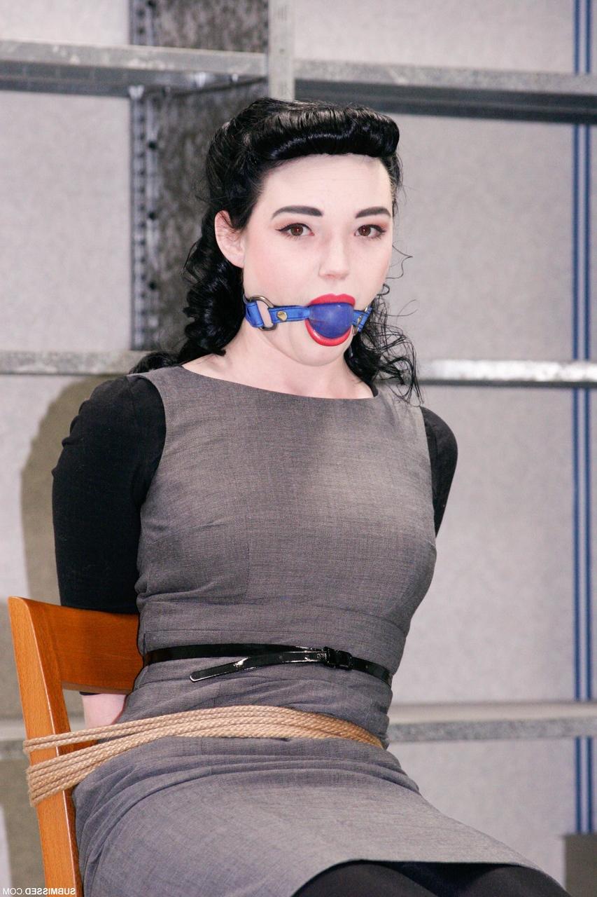 20P Fully clothed gagged babe Lilly struggles to be free of her rope bondage