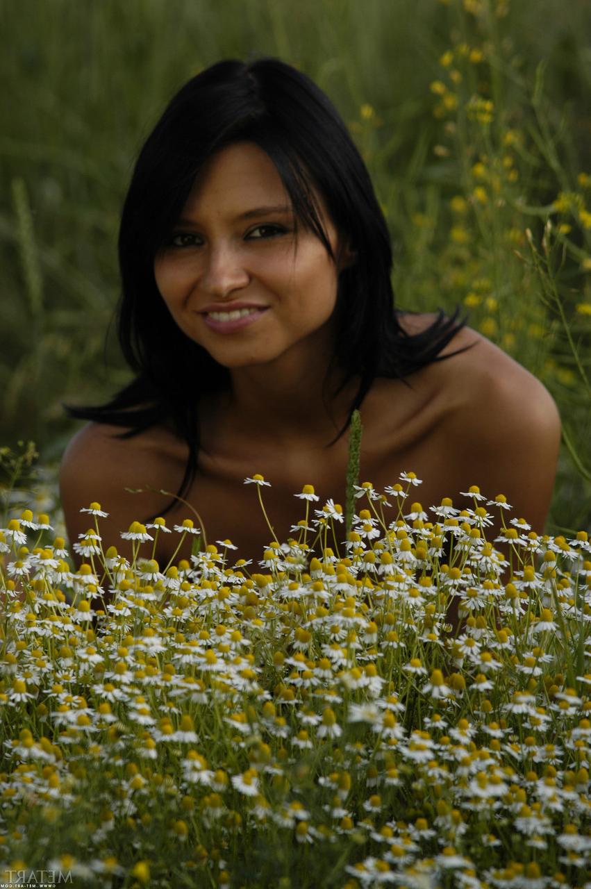 17P Solo-Girl mit schwarzen Haaren und getönten Titten ist ein nacktes Model inmitten wilder Blumen