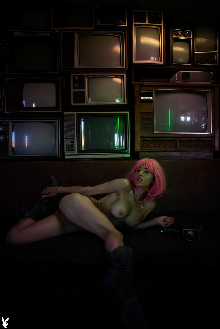 20P Pink haired babe with big tits Noel Leon undresses and poses in front of TVs