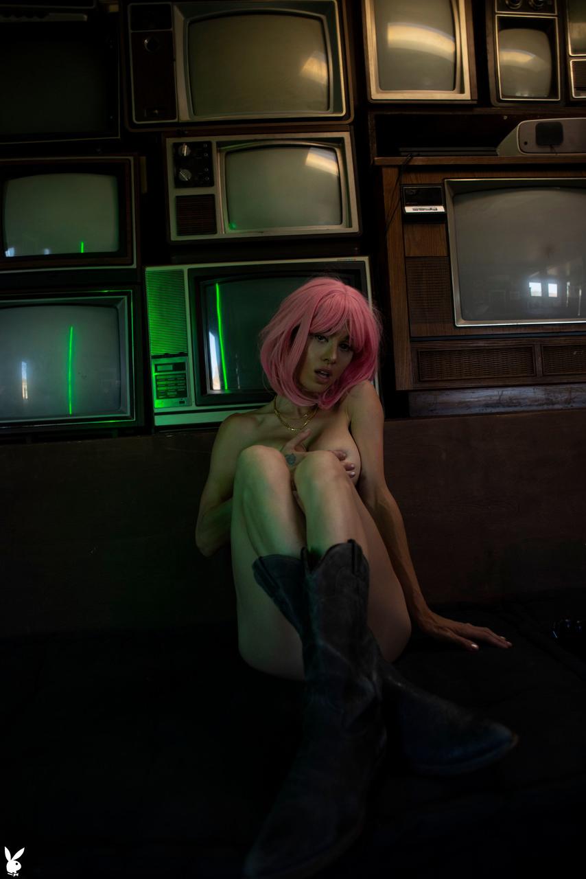 20P Pink haired babe with big tits Noel Leon undresses and poses in front of TVs