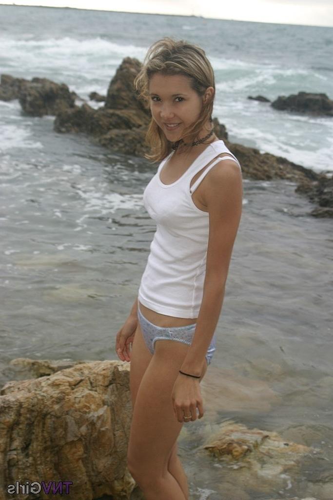 20P A bela magrinha brinca com suas pernas sensuais de calcinha na praia