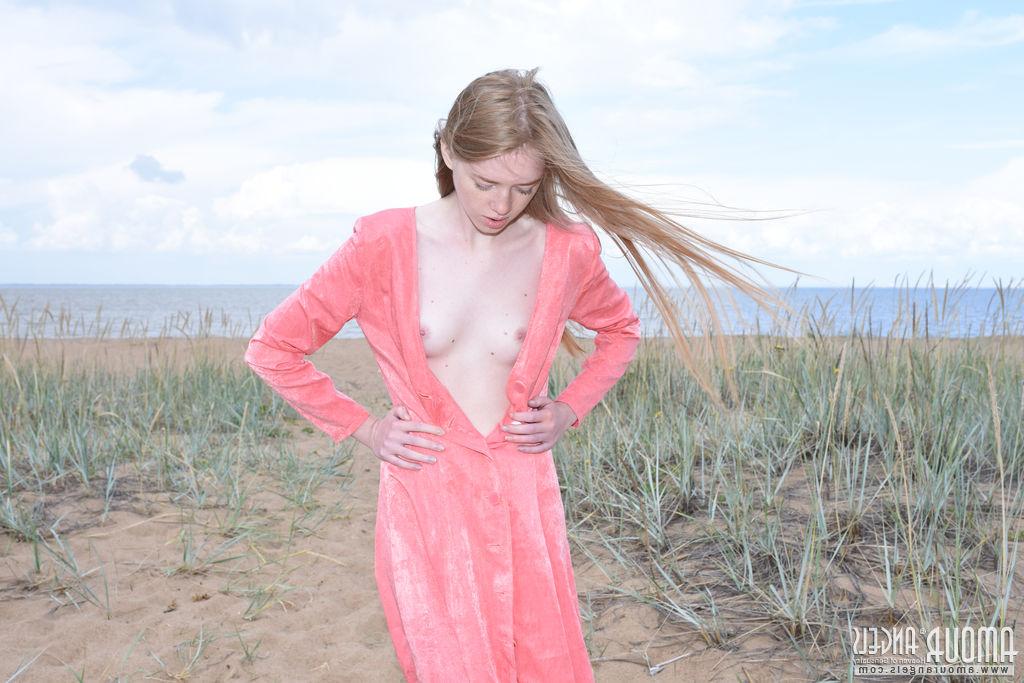 20P Die hellhäutige Teenagerin Gerda zieht sich auf einem Sandfleck am Meer nackt aus