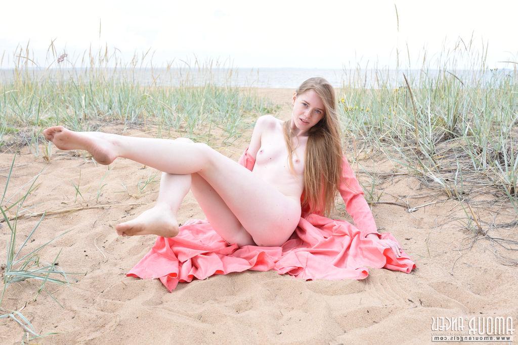20P Die hellhäutige Teenagerin Gerda zieht sich auf einem Sandfleck am Meer nackt aus