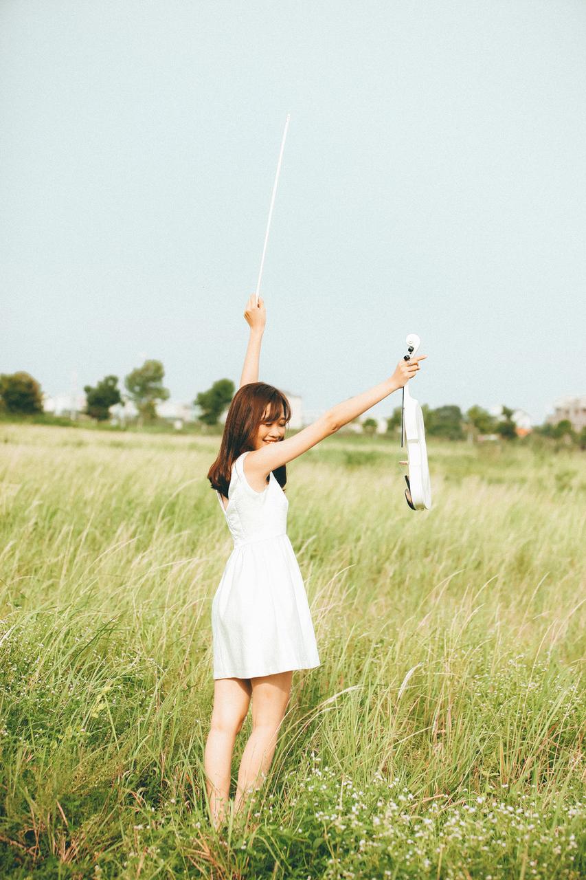 20P Cute Asian musician poses in her white dress while playing a violin outside