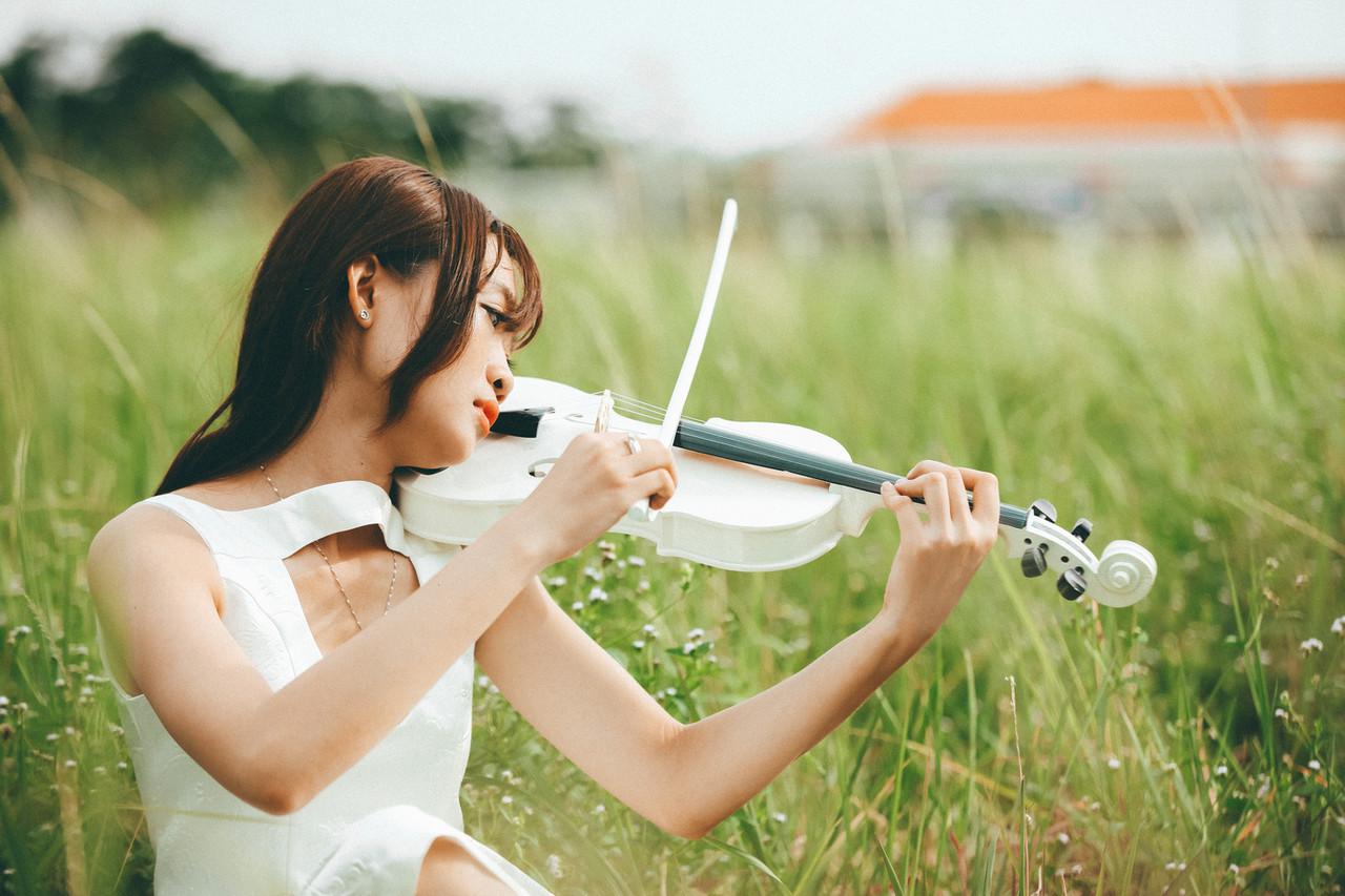 20P Cute Asian musician poses in her white dress while playing a violin outside