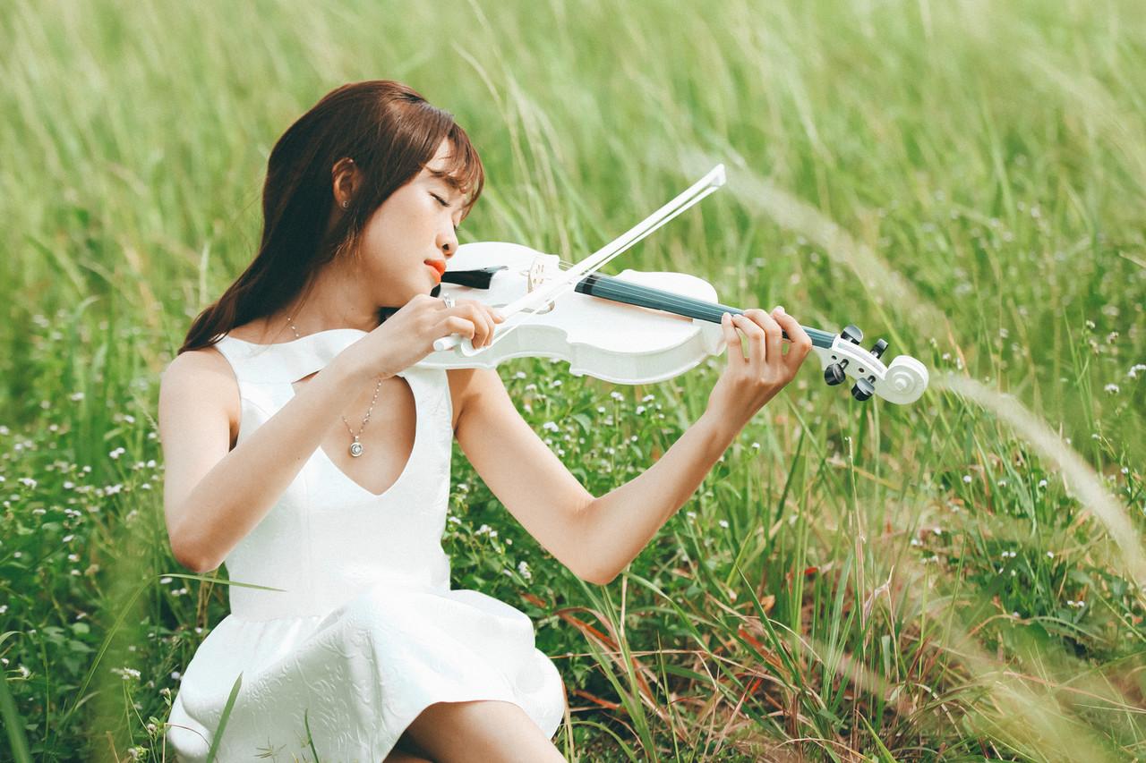 20P Cute Asian musician poses in her white dress while playing a violin outside
