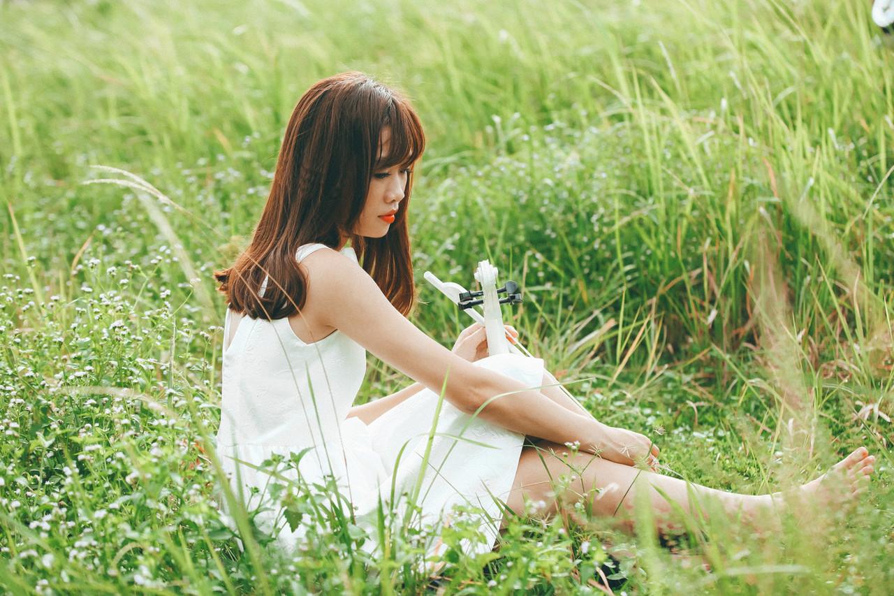 20P Cute Asian musician poses in her white dress while playing a violin outside