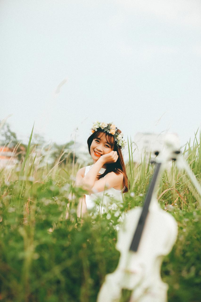 20P Cute Asian musician poses in her white dress while playing a violin outside