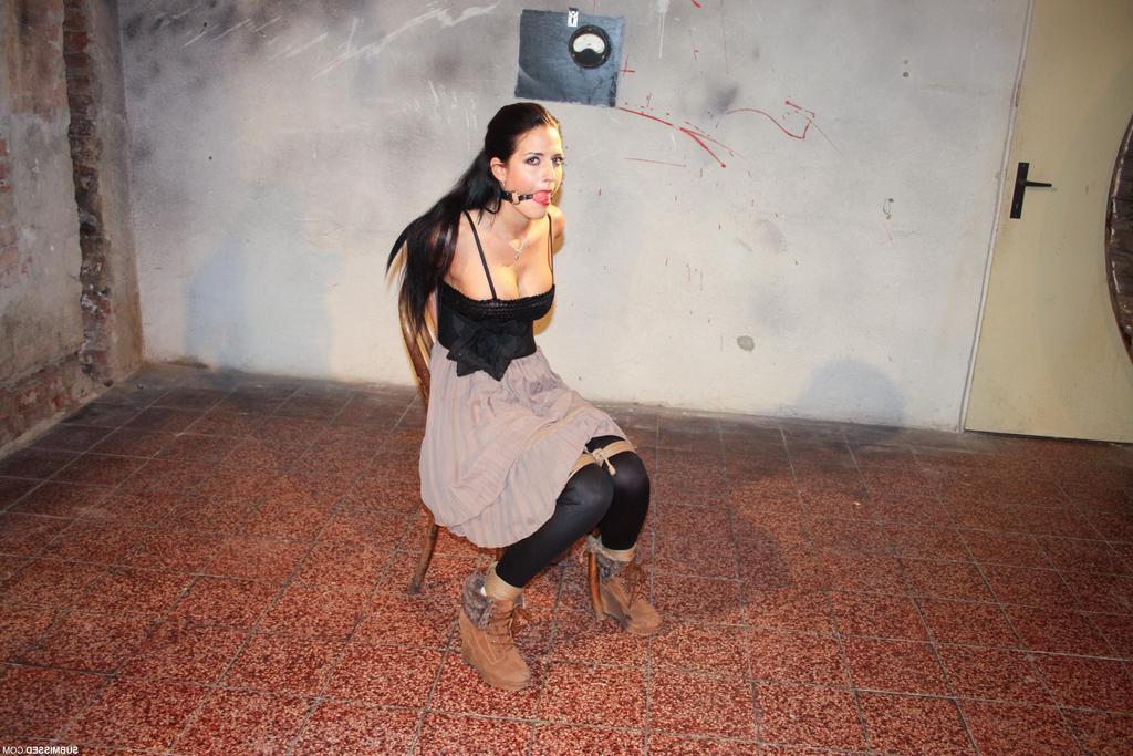 16P A mulher vestida Nicole Vice tem seus seios firmes expostos enquanto está amarrada a uma cadeira