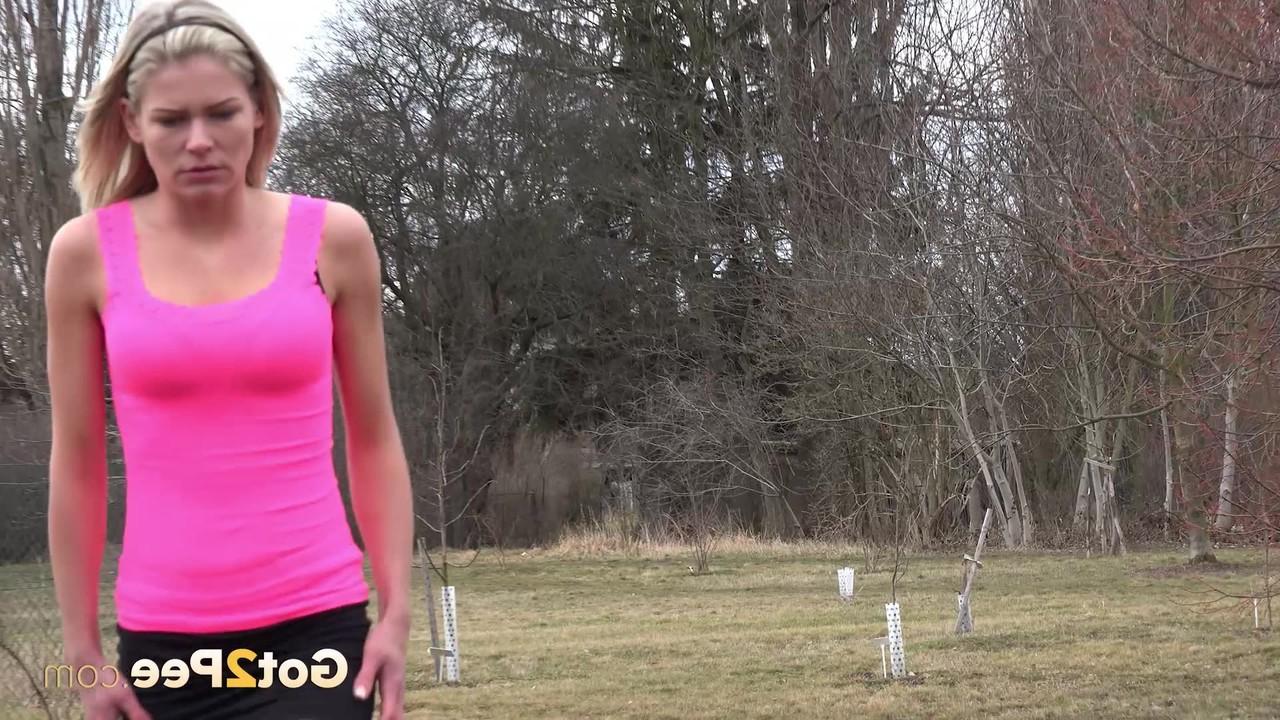 15P La blonde Claudia Macc fait pipi sur des patins dans un champ.