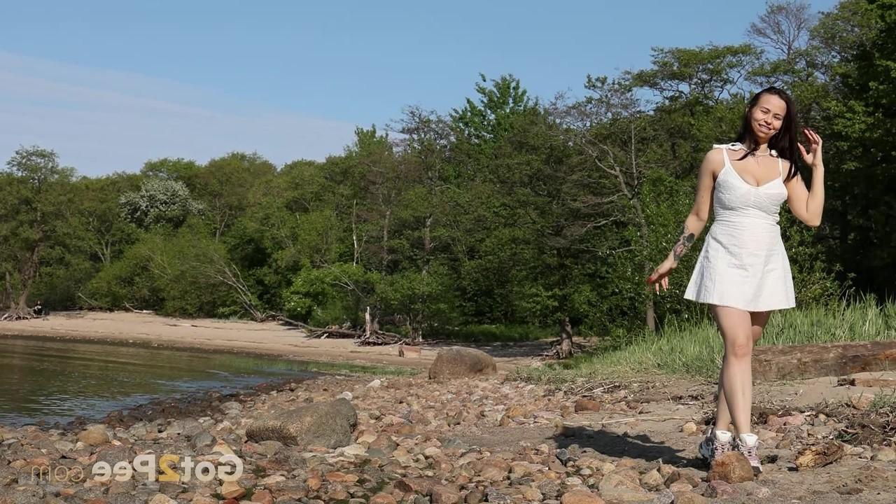 15P Brunette chick Pinky Cat pisses on a boulder at a rocky beach