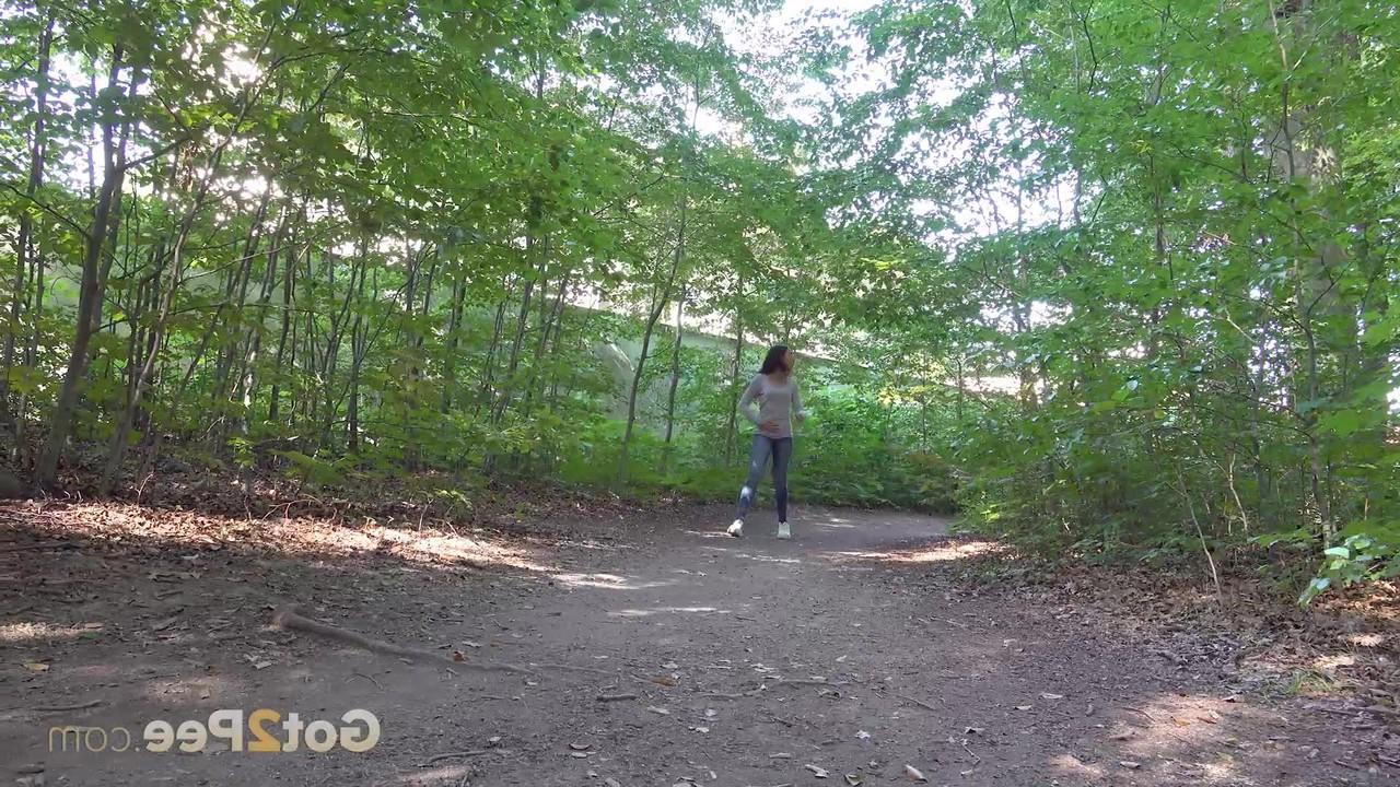 15P Pretty brunette Esperansa pulls down her jeans to take a pee in a forest