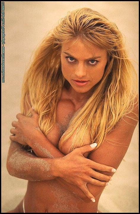 15P A modelo fitness loira Sandy Jones tira a parte superior do biquíni em uma praia