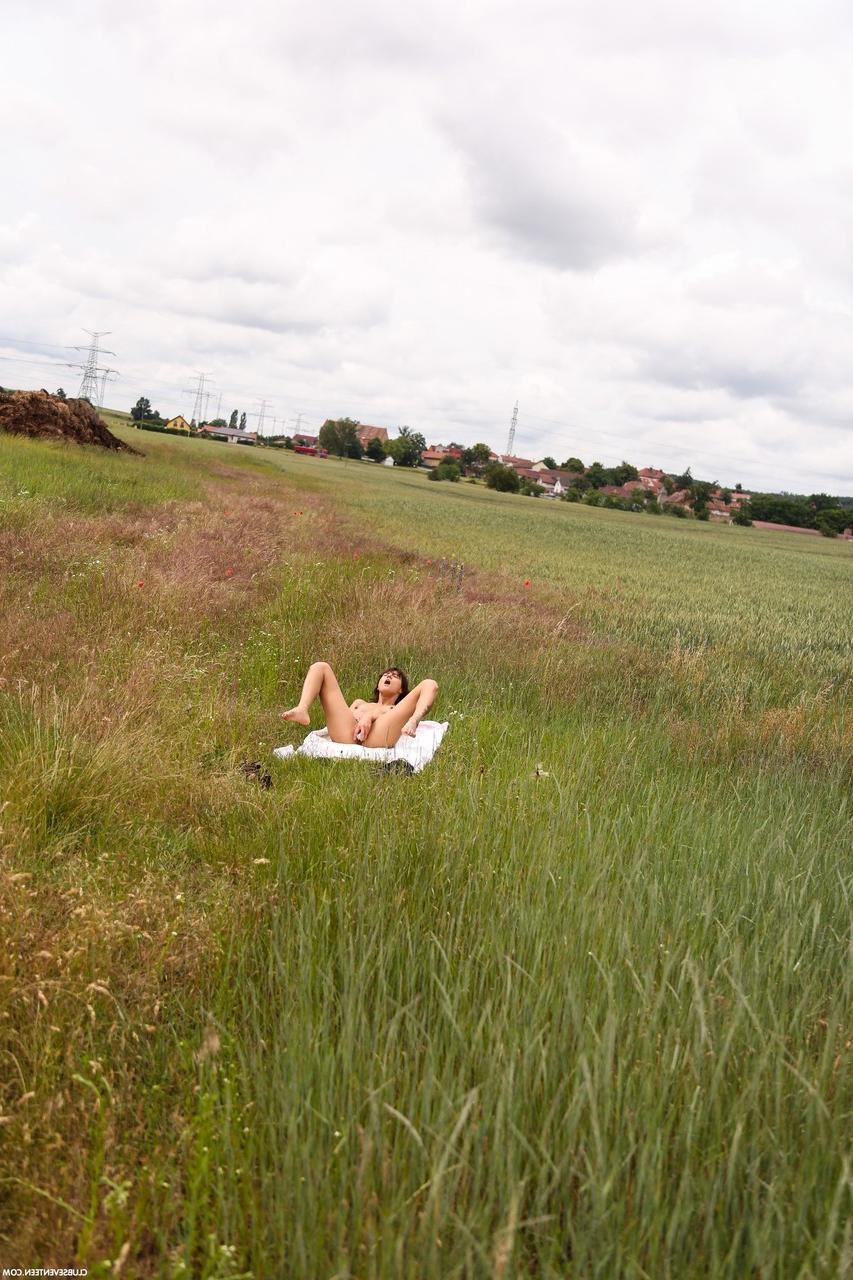 20P Suzy Rainbow, jeune brune et maigre, se déshabille et se masturbe dans la prairie.