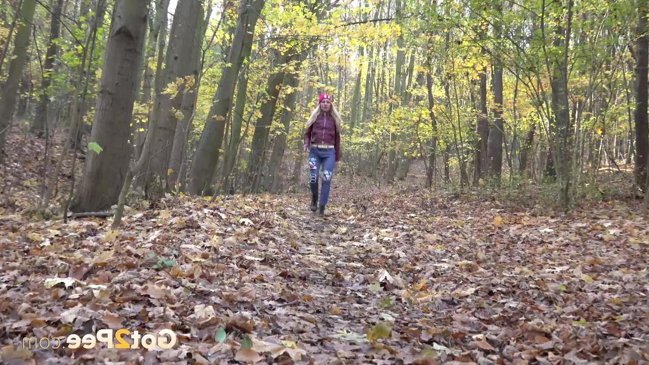 15P Blonde girl Caroli pulls down her jeans to pee on leaves in the woods