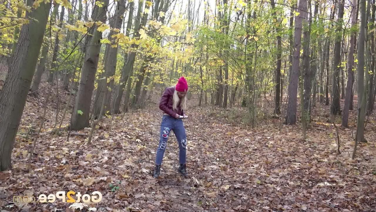 15P Blonde girl Caroli pulls down her jeans to pee on leaves in the woods