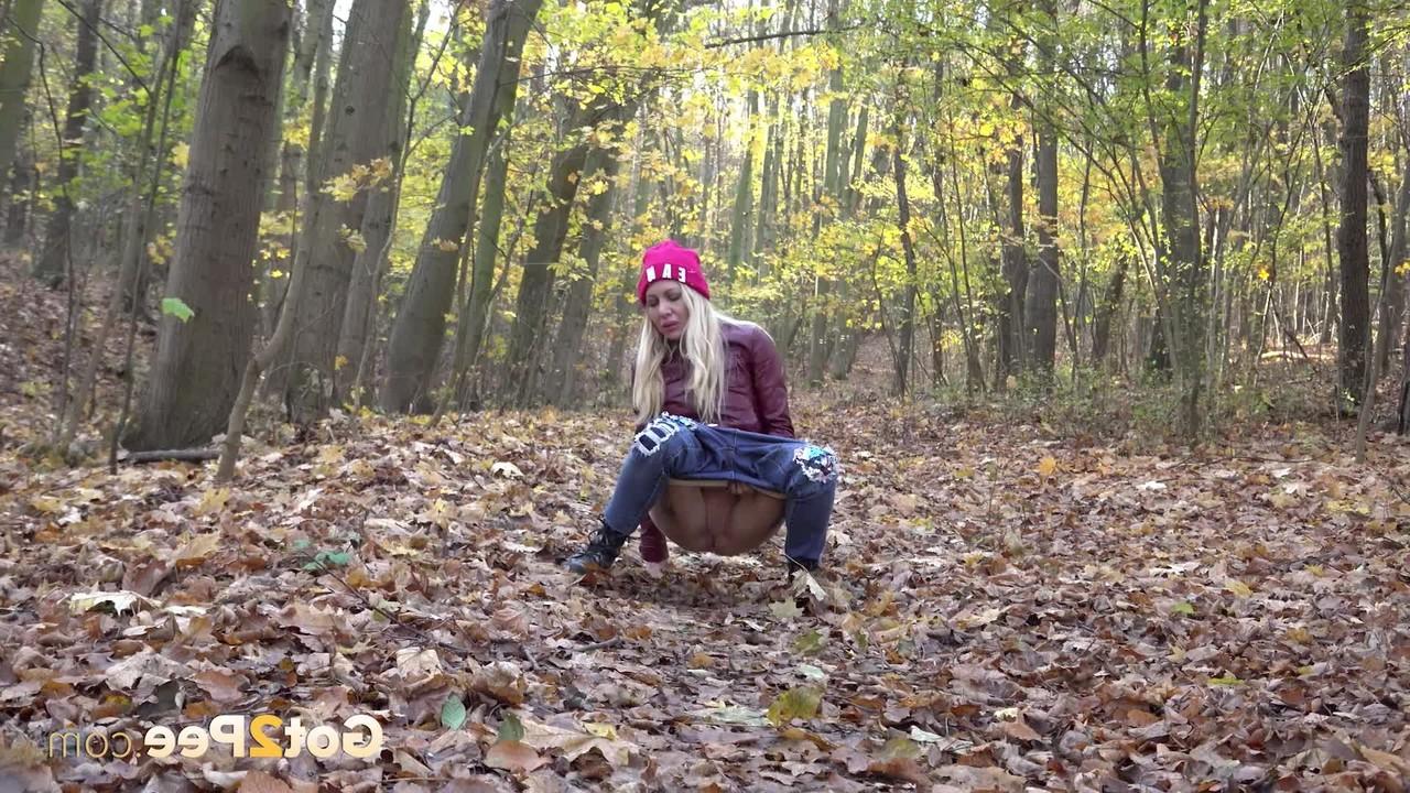15P Blonde girl Caroli pulls down her jeans to pee on leaves in the woods