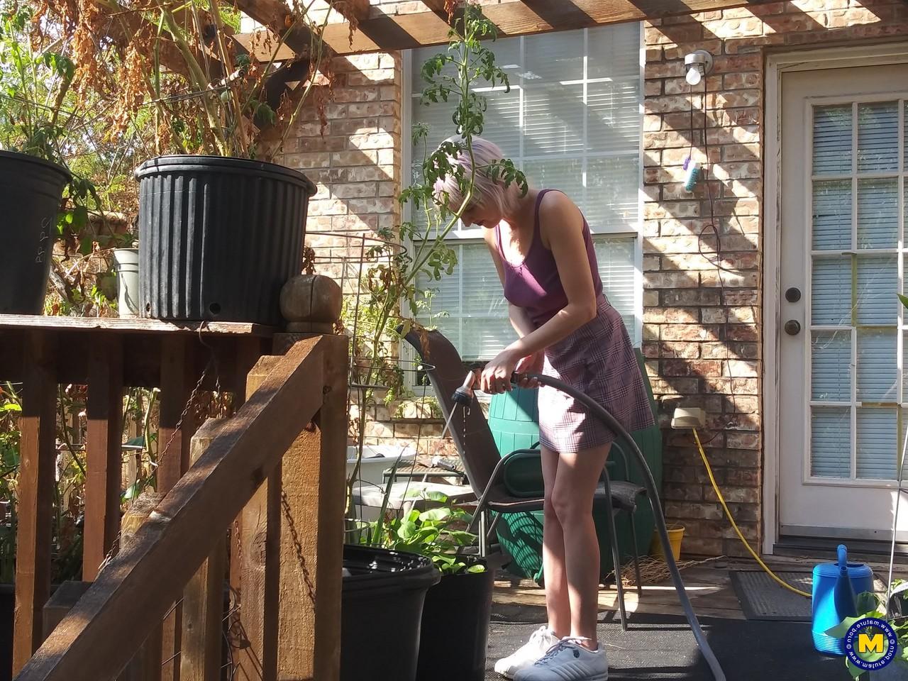 20P Sylvie J, blonde maigre en jupe, exhibe sa chatte dans un jardin intérieur.