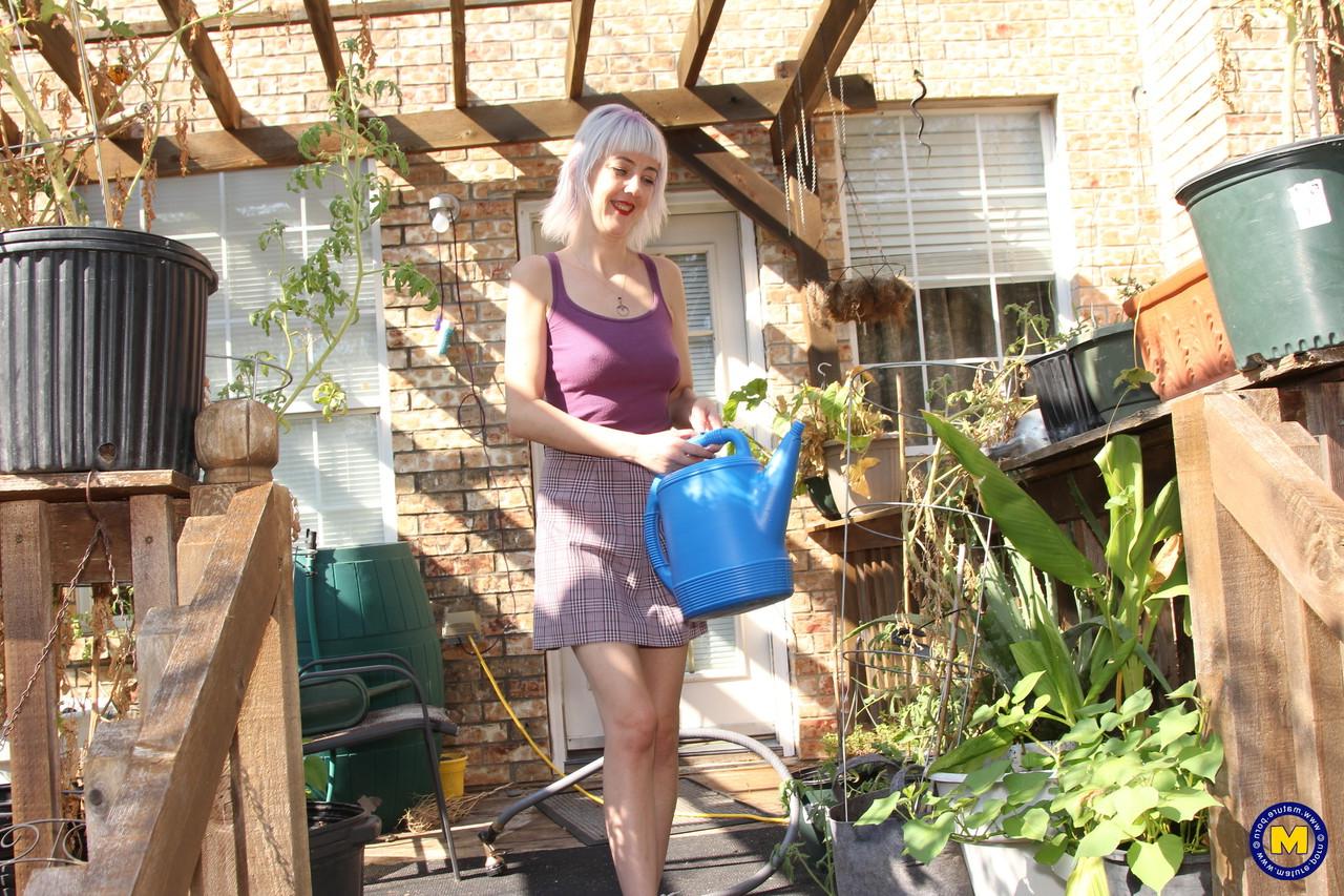 20P Sylvie J, blonde maigre en jupe, exhibe sa chatte dans un jardin intérieur.