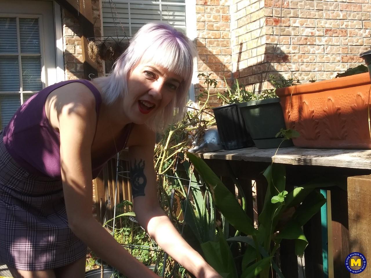 20P Sylvie J, blonde maigre en jupe, exhibe sa chatte dans un jardin intérieur.