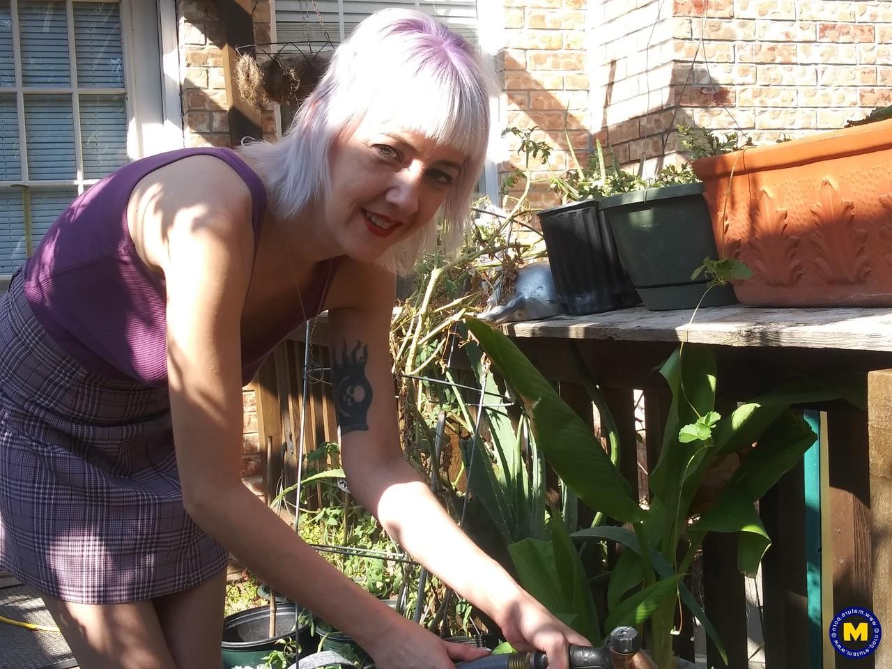 20P Sylvie J, blonde maigre en jupe, exhibe sa chatte dans un jardin intérieur.