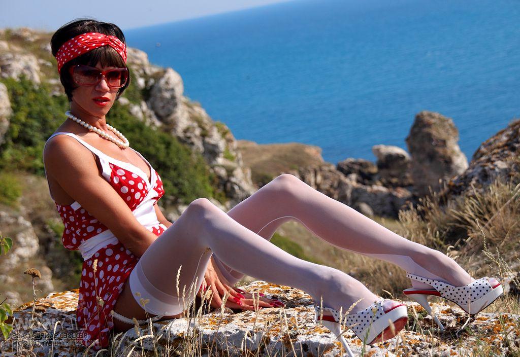 12P Sexy MILF uncovers her breasts on a seaside cliff in white nylons