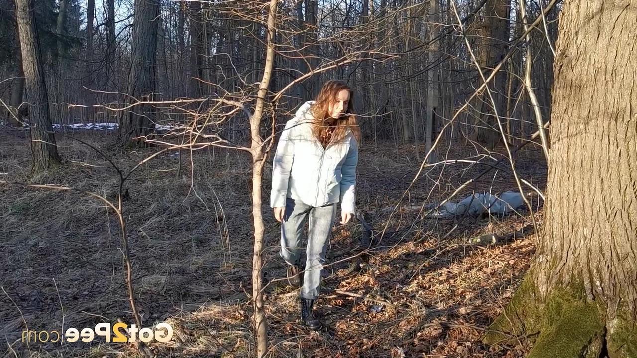 15P Caucasian girl Nikky B leans back against a tree while taking a piss