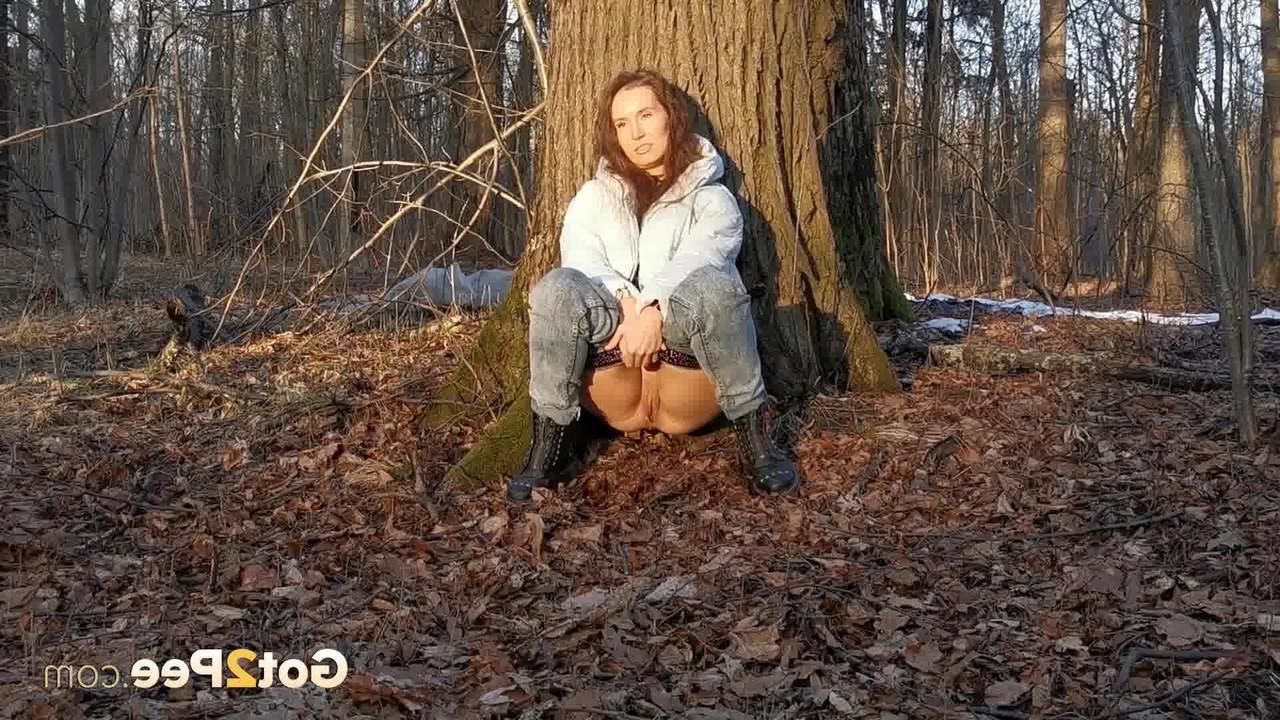 15P Caucasian girl Nikky B leans back against a tree while taking a piss