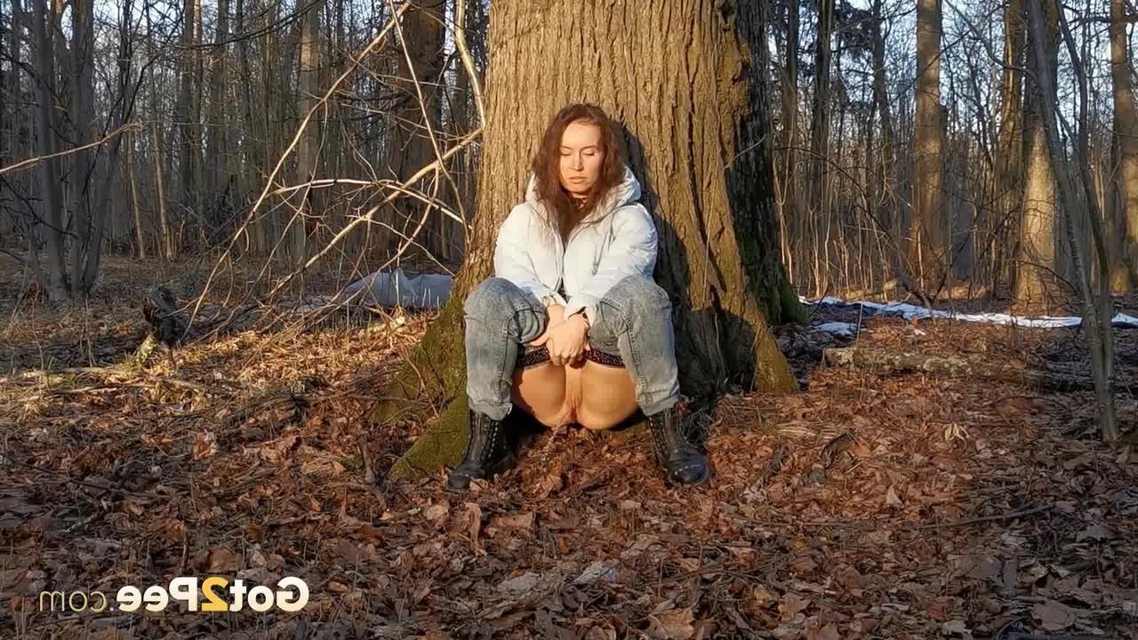 15P Caucasian girl Nikky B leans back against a tree while taking a piss