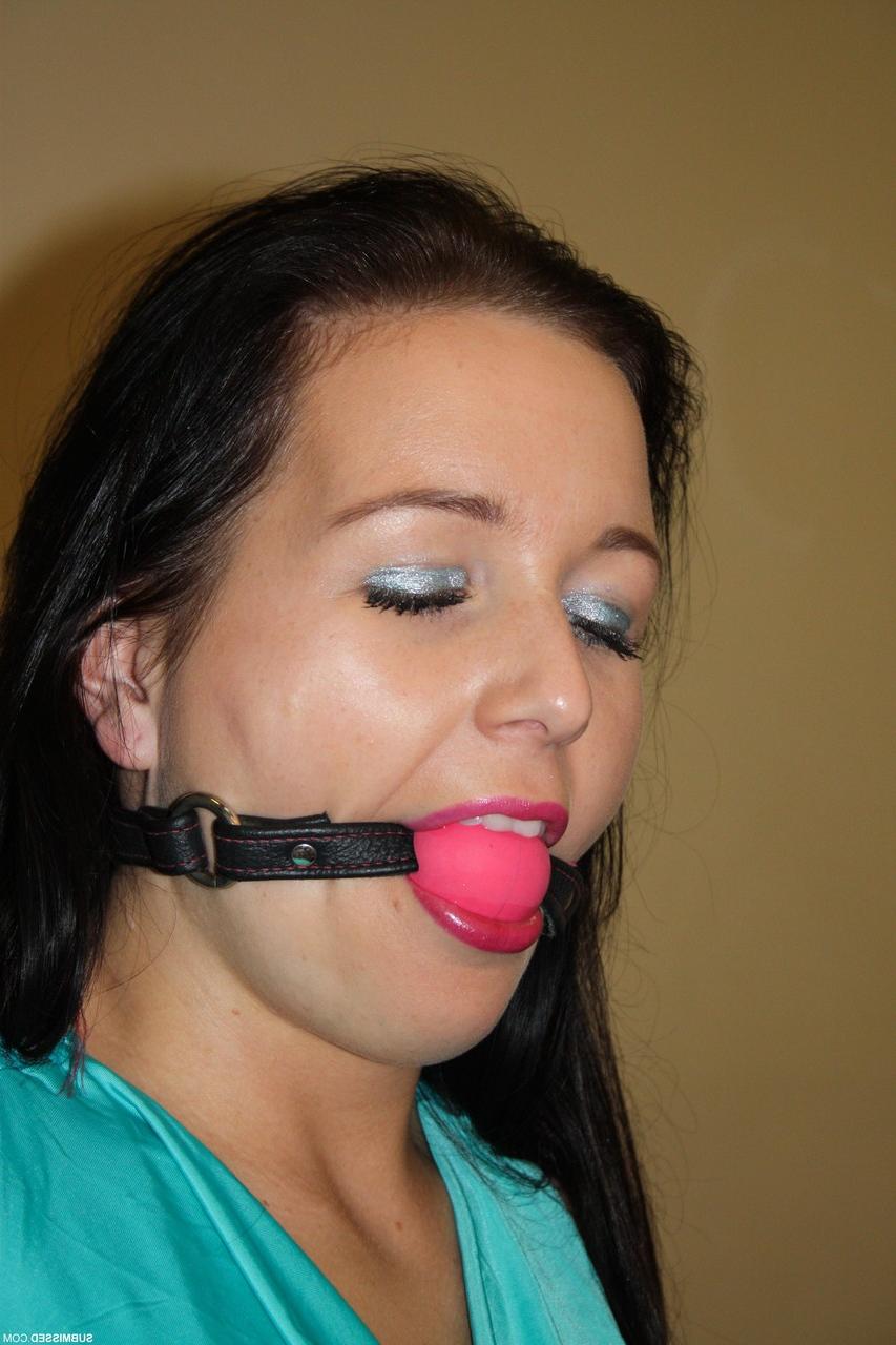 17P Ballgagged brunette is tied to a chair with rope in black pants and heels