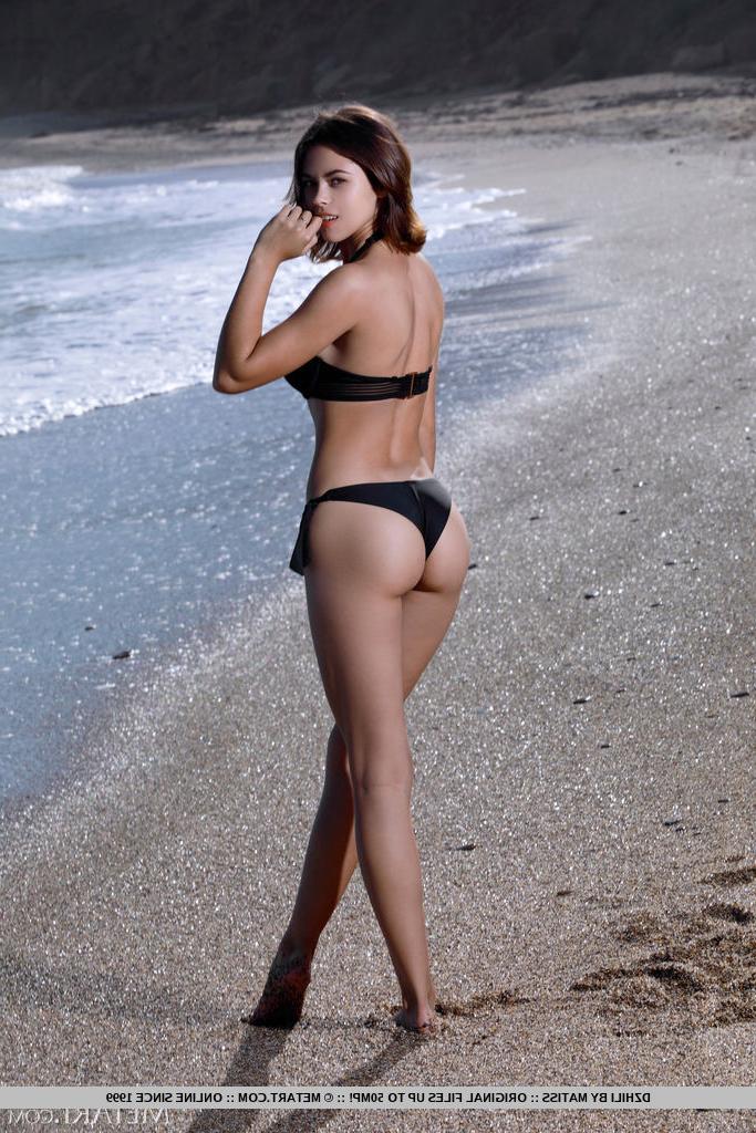 18P A bela garota Dzhili liberta seu grande corpo de um biquíni em uma praia de seixos